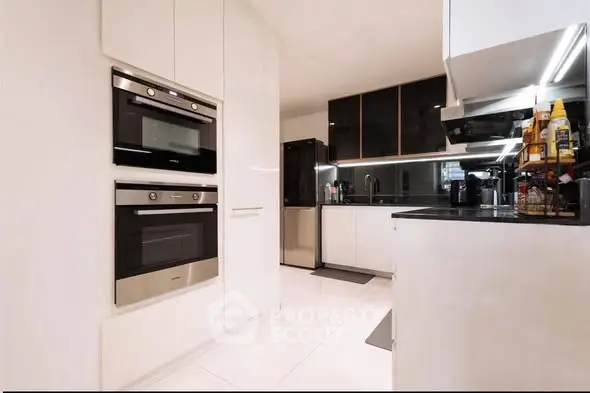 Modern kitchen with sleek appliances and glossy cabinets