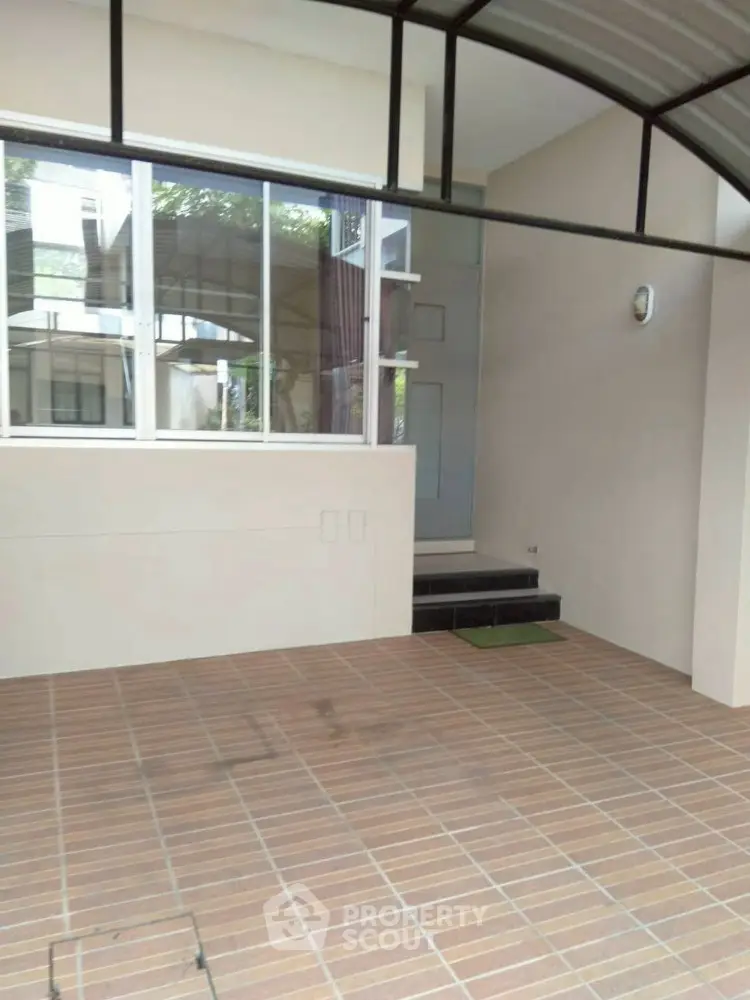 Modern entrance with tiled flooring and large windows in a contemporary home.