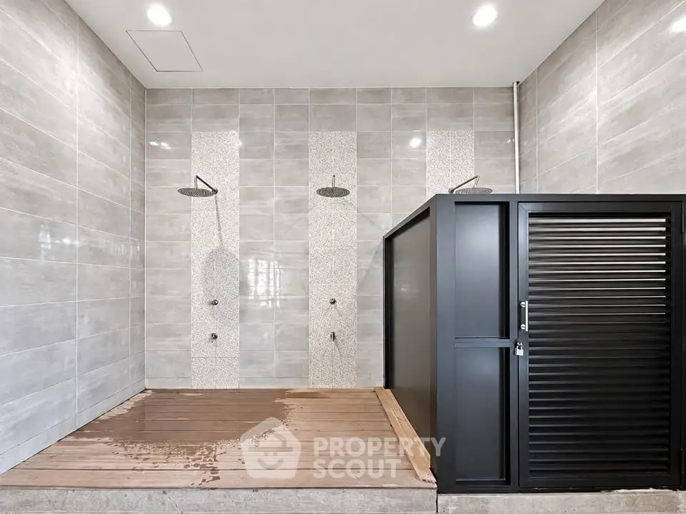 Modern communal shower area with sleek design and dual showerheads.