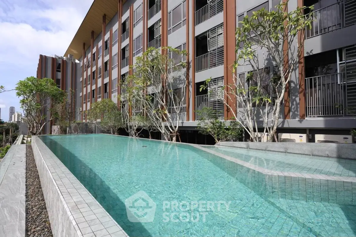 Luxurious modern building with stunning pool and lush greenery