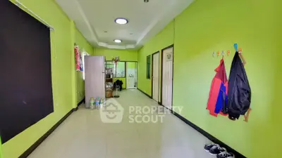 Spacious hallway with vibrant green walls and modern lighting