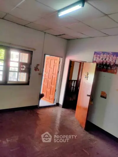 Spacious room with wooden flooring and ample natural light, ideal for versatile living arrangements.