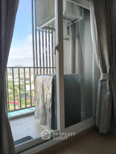 Spacious balcony with city view and sliding glass door, perfect for relaxation.