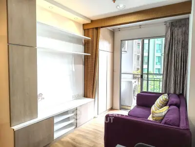Bright living room with modern furniture and balcony access in urban apartment.