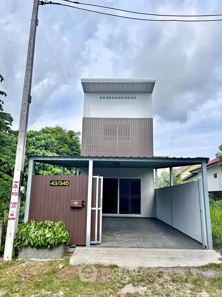 Modern two-story house with minimalist design and spacious driveway, perfect for contemporary living.