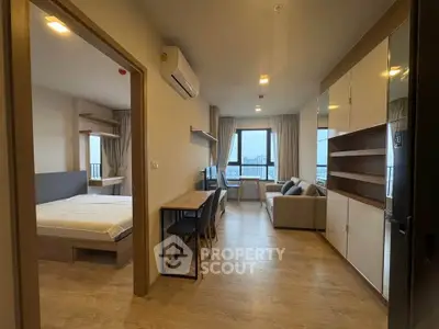 Modern apartment interior with spacious living room and bedroom, featuring large windows and stylish furnishings.