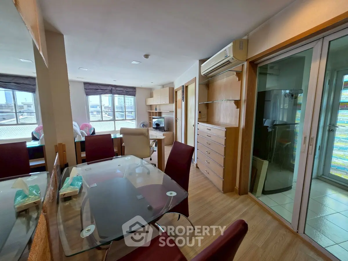 Spacious study room with modern glass table and ample storage in urban apartment