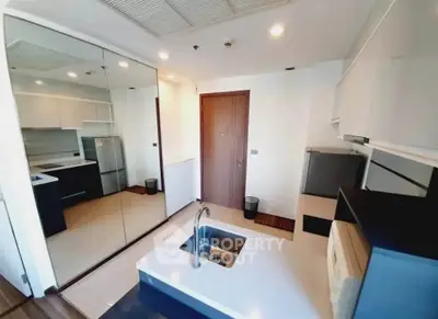 Modern kitchen with sleek design, featuring built-in appliances and a mirrored wall for spacious feel.