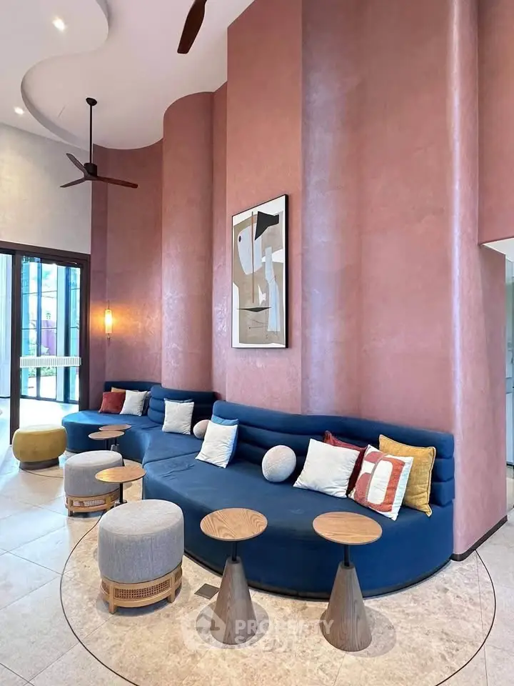 Stylish modern living room with curved blue sofa and artistic decor