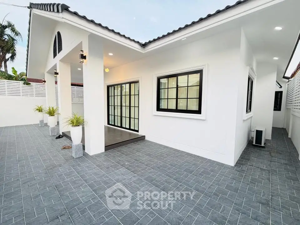 Modern white exterior house with stylish tiled patio and large windows