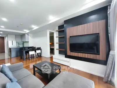 Modern living room with sleek TV setup and stylish furniture in open layout apartment.