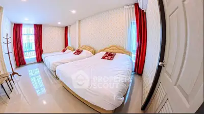 Spacious bedroom with three beds and elegant decor, perfect for family living.