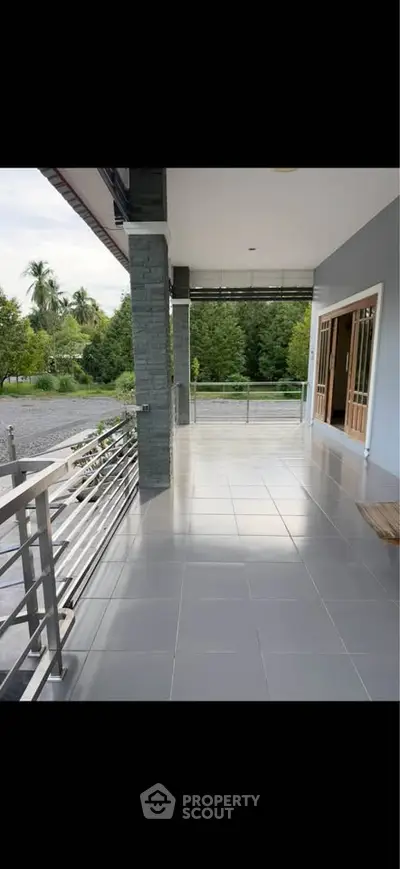 Spacious balcony with scenic view of lush greenery, perfect for relaxation and outdoor gatherings.