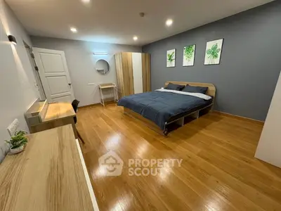 Spacious modern bedroom with wooden flooring and stylish decor
