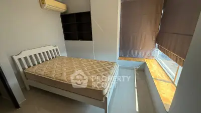 Cozy bedroom with natural light and modern design, featuring a comfortable bed and stylish window shades.