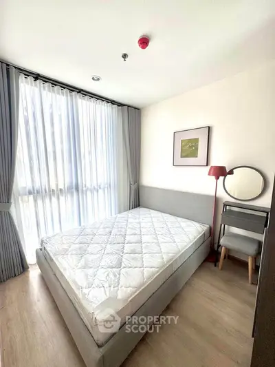 Modern bedroom with natural light, stylish decor, and cozy furnishings for a comfortable living experience.