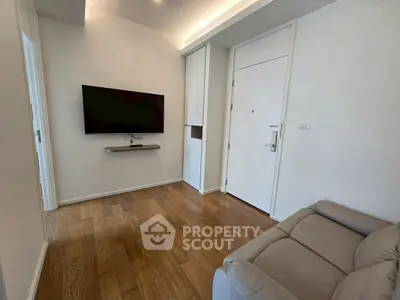 Modern living room with wall-mounted TV and sleek wooden flooring