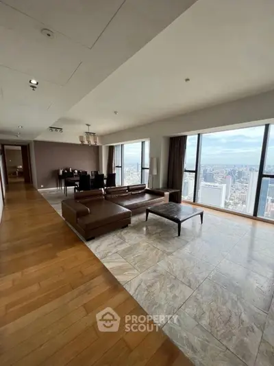 Luxurious living room with panoramic city views and elegant furnishings in a high-rise apartment.