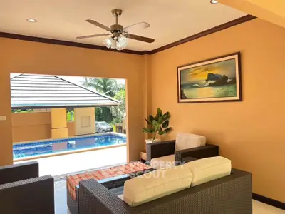 Charming living room with pool view, featuring cozy seating and elegant decor, perfect for relaxation and entertaining.