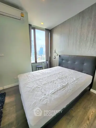 Modern bedroom with city view, featuring a large bed and stylish decor, perfect for urban living.