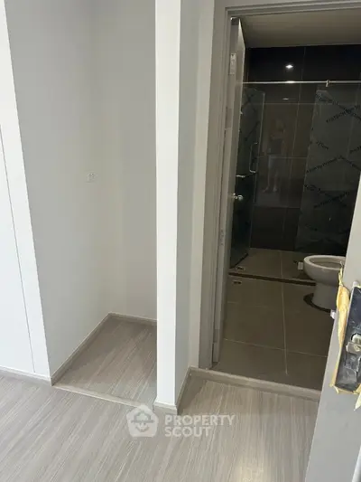 Modern bathroom with sleek design and glass shower enclosure in a contemporary apartment.