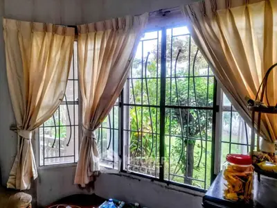 Cozy living room with garden view through large windows and elegant curtains.