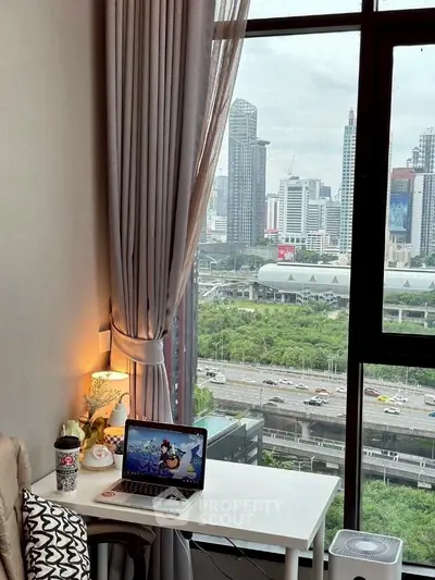 Modern study area with city view from high-rise apartment window.