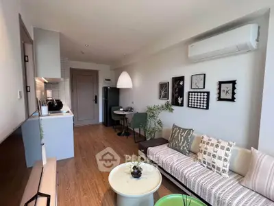 Modern living room with stylish decor and open kitchen layout, featuring cozy seating and contemporary design.