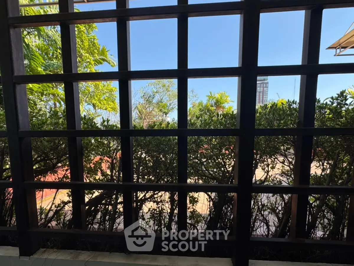 Scenic garden view through a stylish wooden trellis, perfect for serene outdoor living.