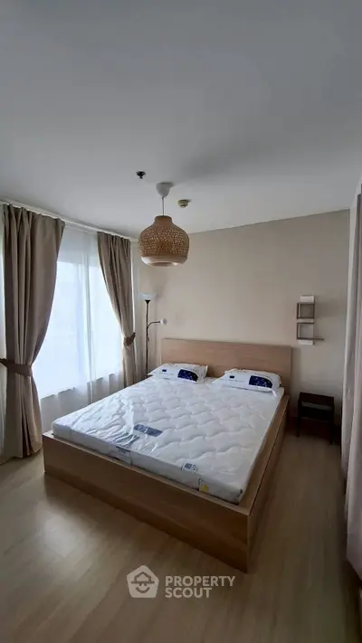 Spacious bedroom with modern decor and large windows for natural light.