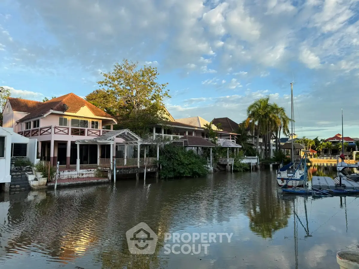 Charming waterfront homes with lush greenery and serene canal views.