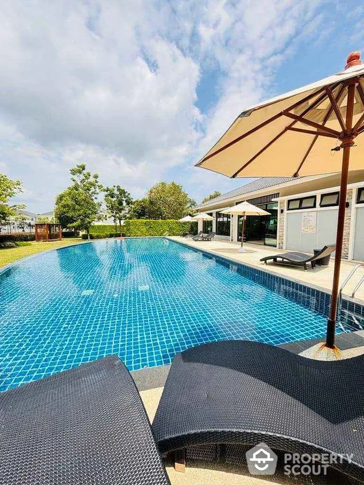 Luxurious outdoor pool area with sun loungers and umbrellas, perfect for relaxation and leisure.