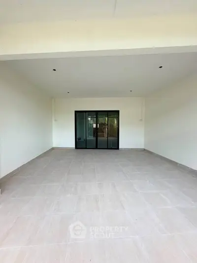 Spacious covered patio with sliding glass doors, perfect for outdoor gatherings and relaxation.