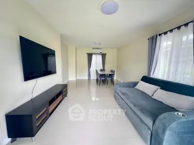 Spacious living room with modern sofa and wall-mounted TV, perfect for relaxation.