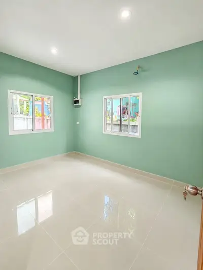 Spacious empty room with green walls and tiled floor, perfect for customization.