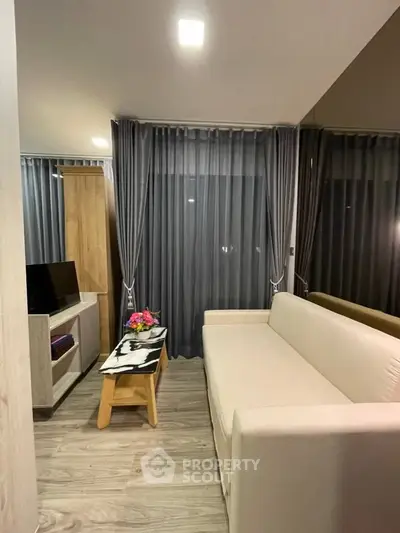 Modern living room with elegant decor and cozy ambiance, featuring a sleek sofa and stylish curtains.