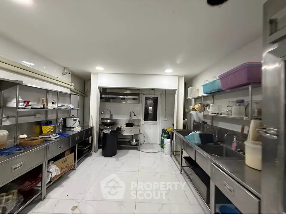 Spacious commercial kitchen with stainless steel appliances and ample storage space.