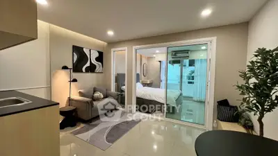Modern studio apartment with cozy living area and glass partitioned bedroom.