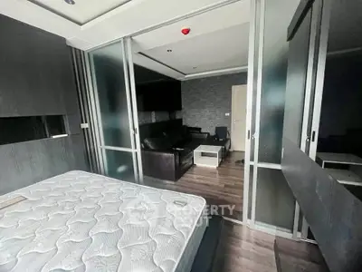 Modern bedroom with sliding glass doors and sleek dark furniture