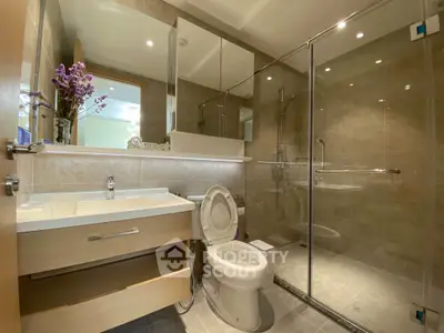 Modern bathroom with glass shower and elegant fixtures in a stylish home.