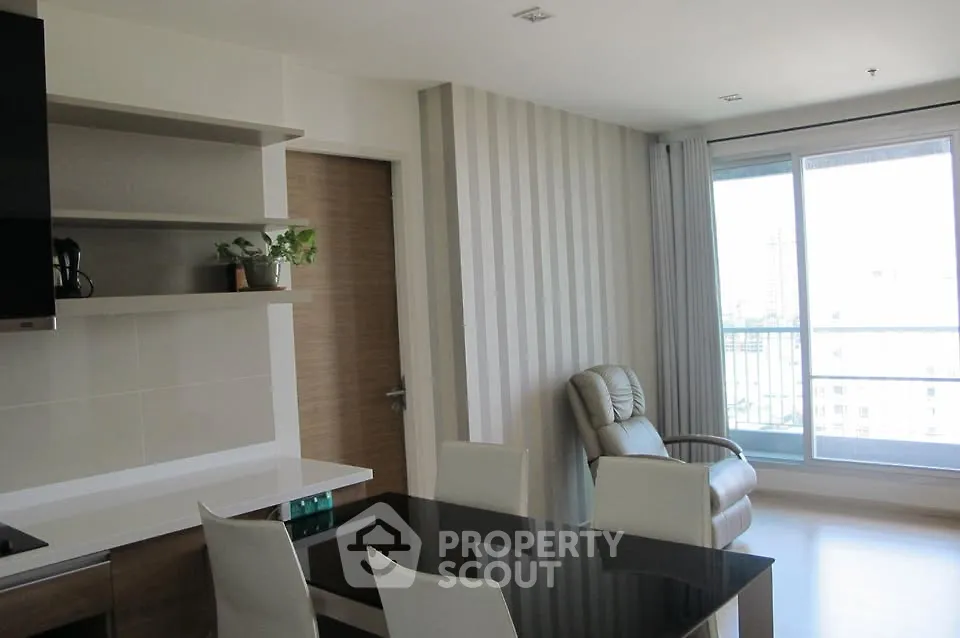 Modern living room with sleek furniture and large window offering city views