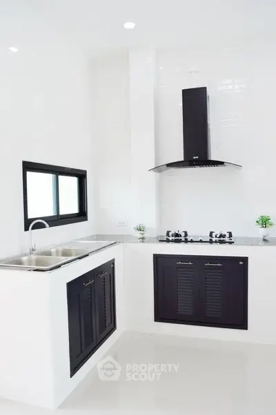Modern kitchen with sleek black cabinets and gas stove in minimalist design