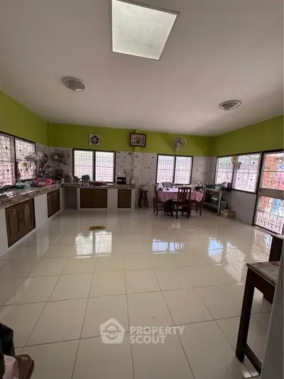Spacious kitchen with tiled floor and ample natural light, featuring a closed layout and dining area.