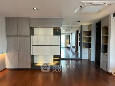 Spacious modern living room with wooden flooring and built-in storage