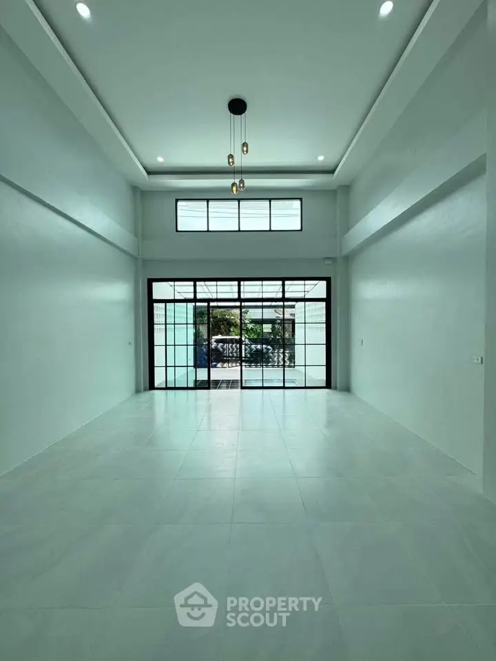Spacious modern living room with high ceilings and large windows offering natural light.
