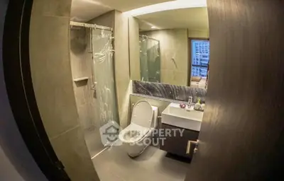 Modern bathroom with sleek design and glass shower enclosure in urban apartment.