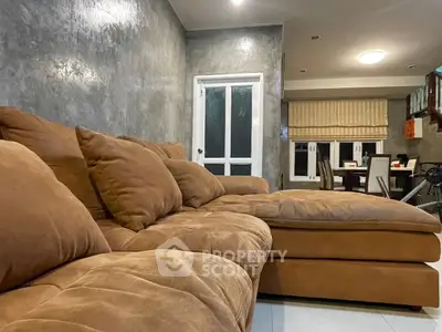 Cozy living room with plush brown sectional sofa and modern dining area