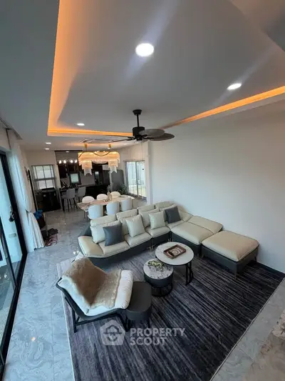 Luxurious open-concept living room with modern decor and elegant lighting, perfect for entertaining.