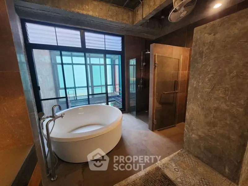 Luxurious modern bathroom with round bathtub and glass shower enclosure