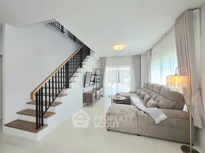 Modern living room with stylish staircase and cozy seating area.